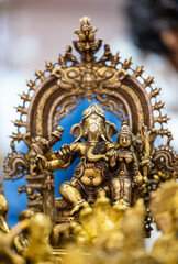 Lord Ganesh idol made with brass with blur background. Selective focus on sculpture.