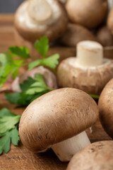 Macro closeup of portobello mushrooms on wooden table with parsley, selective focus, vertical