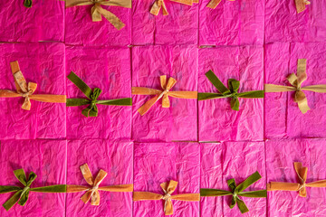 Naklejka premium Pink envelopes decorated with colorful ribbons and bows are stacked together on the table, top view. Background image on a greeting and holiday theme