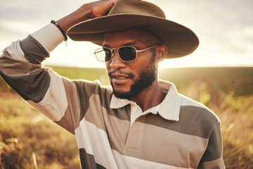 Farm, agriculture and sustainability with a black man in a field, meadow or grass while farming in...