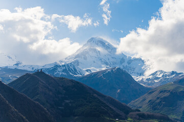 ascending view of Gergeti Trinity Church and Mkinvartsveri in the background, Kazbegi, Georgia. High quality photo
