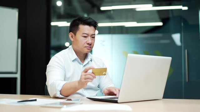 Asian Businessman making Online Payment Failure on laptop computer in Office. Male worker has difficulty problem fail With credit card. Employee could not complete transaction not enough money