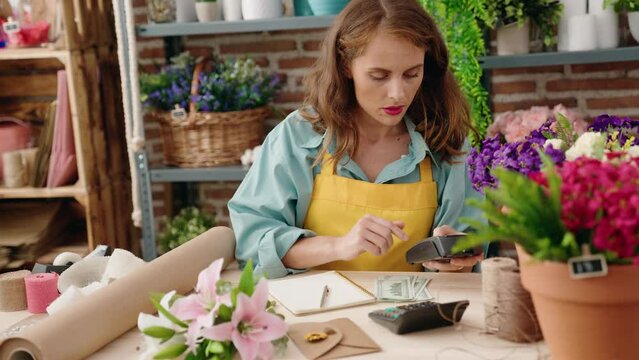 Young beautiful hispanic woman florist counting dollars at florist