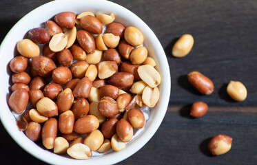 Salt peanuts in a cup on the wooden floor