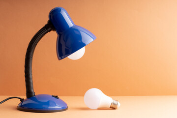 replacing a light bulb in a table lamp, one light bulb in the lamp another on the table
