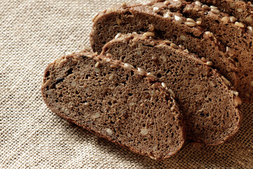 sliced dark whole grain bread in slices on a fabric background