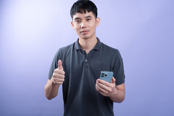 Handsome businessman shooting a photos in studios. On the purple background.