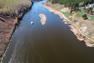 the ship floats along the river, along the banks of the river there is a road and trees