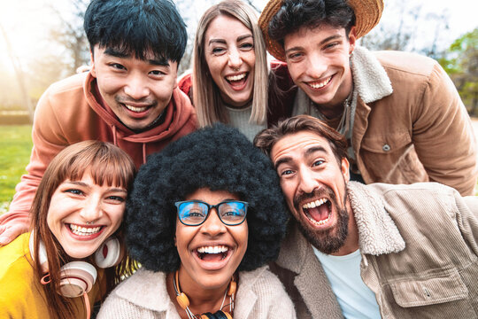 Multicultural young people smiling at camera - Happy group of multiracial students having fun in college campus - Friendship concept with guys and girls hangout outside