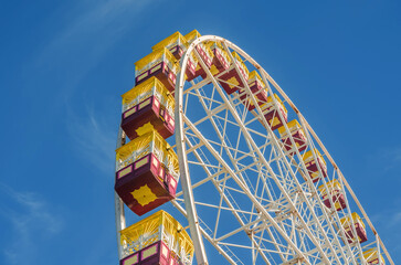 Ferris wheel gondolas against a blue sky