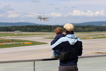 Father and son watching a plane during take off