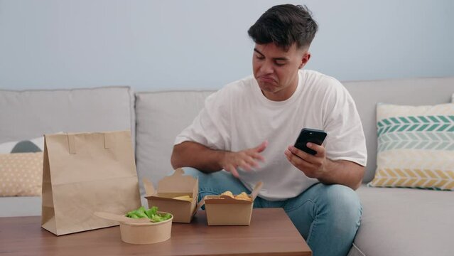 Young hispanic man make photo by smartphone to take away food at home