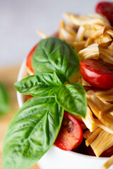 smoked cheese with tomatoes and basil in a white plate on a wooden board