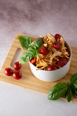 smoked cheese with tomatoes and basil in a white plate on a wooden board