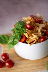 smoked cheese with tomatoes and basil in a white plate on a wooden board