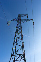 Electrical high voltage pylon with blue sky in background.