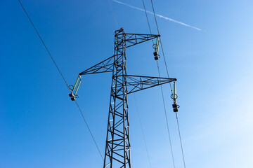 Electrical high voltage pylon with blue sky in background.