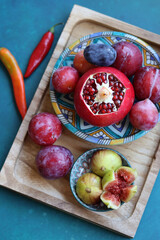 Still life with fresh Israeli fruits on a blue ceramic plate. Colorful picture of juicy fruit. 