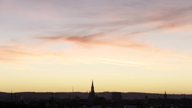 Time lapse shot of the cities of Neu-Ulm and Ulm with Ulm Minster while colorful dusk in red and orange seen from hill in city part &bdquo;Pfuhl&ldquo; of Neu-Ulm (Kapellenberg)
