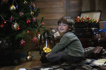 Сhild is sitting with Christmas decorations