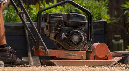 Zagęszczanie żwiru jako podbudowy pod nawierzchnię tarasu . © Grzegorz