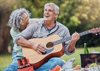 Elderly, couple and guitar at happy picnic in garden, park or nature together. Man, woman and music...