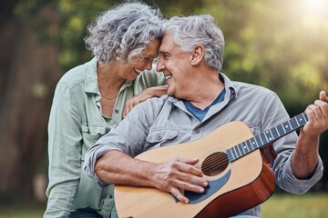 Senior couple, guitar and love in a park together playing a romantic, love or affection music song for wife. Romance, retired senior man and woman play string instrument and laugh outdoor in forest