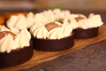 Tart slice with meringue on a dark background. Side view. Professional dessert. Coconut filling, coco inside the tart.