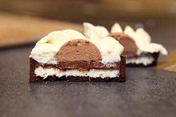 Tart slice with meringue on a dark background. Side view. Professional dessert. Coconut filling, coco inside the tart.