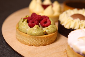 Tart with raspberry and cream. Pie with meringue. Set of desserts. Set of tarts. Different filling, and topping inside dessert. Pistachio cream.