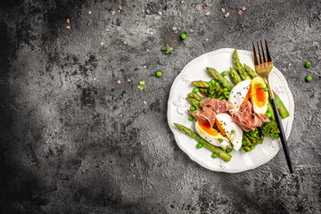 Ketogenic diet meal Poached egg with asparagus spears and prosciutto toast. banner, menu recipe place for text, top view