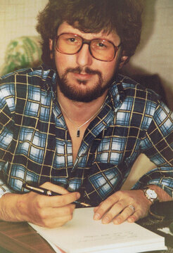 Vintage photo taken in 1982 with an analogue camera. It shows a man of 29 with glasses and beard who writes with a fountain pen