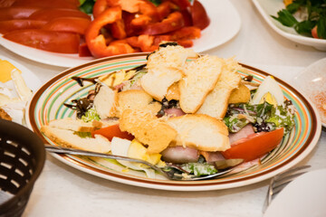 Salad with croutons, cheese, tomatoes, egg and ham dressed with soy sauce.