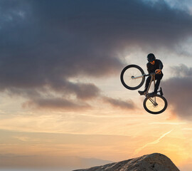 Fototapeta na wymiar Mountain bike, jump and sport with mockup of a man athlete with energy and speed in nature. Healthy sports person with speed jumping and cycling with his bicycle at sunset on mountains with mock up