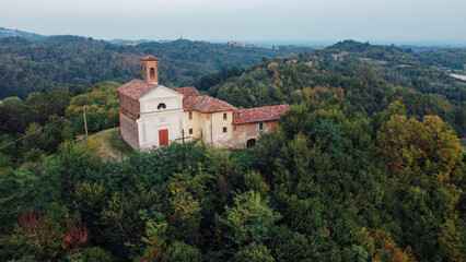 Fototapeta na wymiar Christian church in Piedmont hills, Northern Italy, aerial view. Autumn landscape.