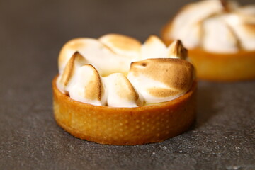 The tart cooking process, dessert in the oven, baking of tarts. Side view, top view. Professional dessert-making process. After baking dark and baked meringue. Closeup tart with peel.