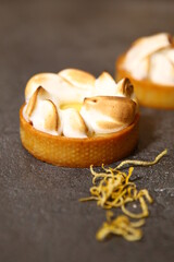 The tart cooking process, dessert in the oven, baking of tarts. Side view, top view. Professional dessert-making process. After baking dark and baked meringue. Closeup tart with peel.