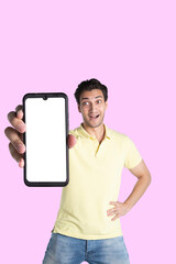 Fototapeta na wymiar Handsome smiling man showing smartphone with white screen isolated on pink background. Mobile Application and advertising concept