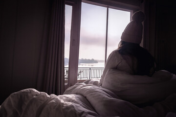 person looking out window in the morning