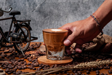 Kawa espresso  na drewnianym stole pełnym świeżo palonych ziaren kawy