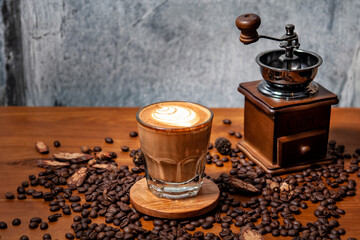 Kawa i młynek do kawy na stole pełnym świeżo palonych ziaren