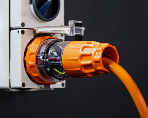 an orange industrial power plug on the wall