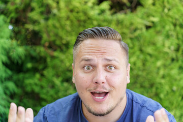 Delighted young man gesturing at the camera