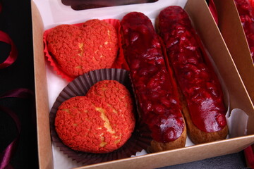 Creative eclair shapes. Eclair with cherry glaze, heart-shaped eclair. St Valentine's Day dessert, heart cupcake, eclair with cherry jelly. heart-shaped dessert, creative pastry, jelly decoration.