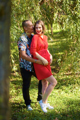 Fototapeta premium Lovely pregnant couple walking in a park
