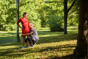 Lovely pregnant couple walking in a park