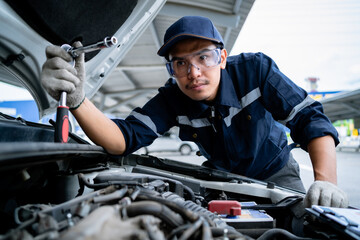 Repair service concept. Asian mechanic checking the safety of a car. Maintenance of damaged parts in the garage. Maintenance repairs. 