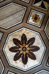 fragment of an old scratched parquet floor. geometric pattern with flower.