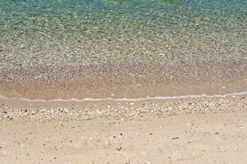 Fototapeta na wymiar Details of sand, beach, sea and shore with plenty of pebbles along the beach.