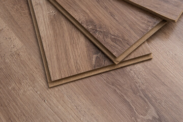 Installing laminated floor, detail on wooden tiles ready to be fit.